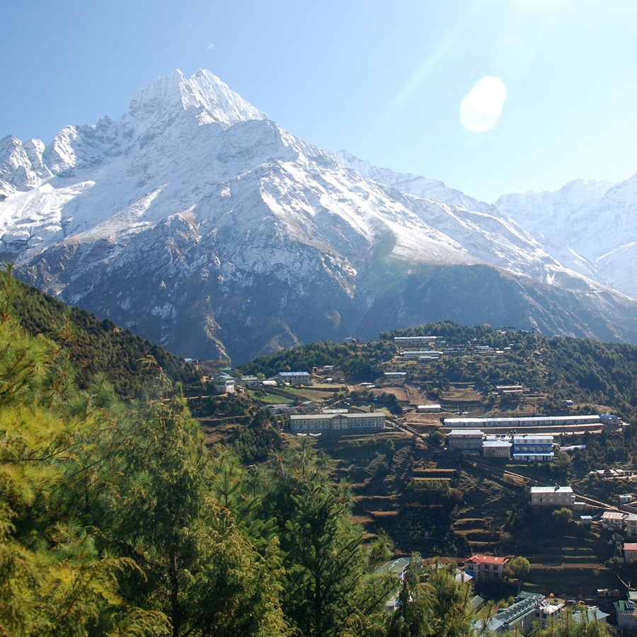 sunshine over himalayan mountains and village