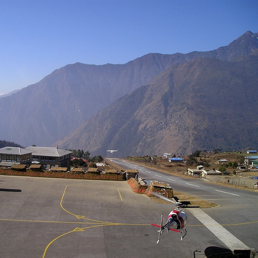 Airplane and helicopter taking off at Lukla Airport 